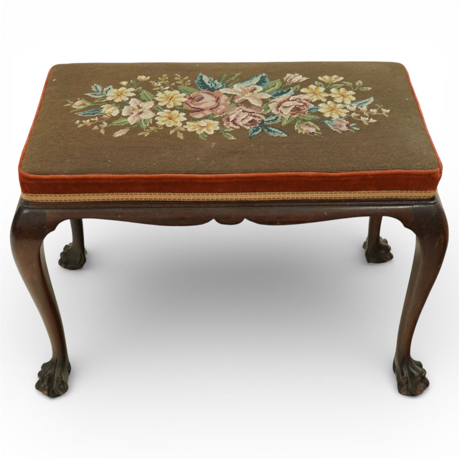 Georgian style mahogany dressing stool, rectangular upholstered top embroidered with a floral needlework panel within a velvet border and braid trim, moulded frieze, raised on cabriole legs terminating in large carved claw and ball feet