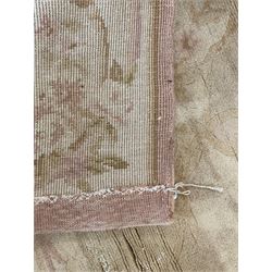 Chinese Savonnerie beige ground rug, central medallion surrounded by scrolling acanthus leaves and floral bouquets in soft pastel hues, wide border with floral garland and vine arrangement, the corners with floral sprays (198cm x 139cm); Chinese Savonnerie beige ground rug, oval central medallion, scrolling acanthus leaf and rose borders, wide band with floral garlands and rococo-design scrolls (198cm x 135cm)