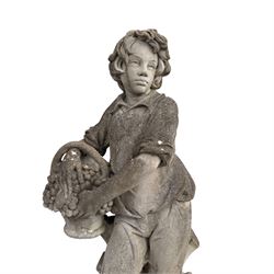 Haddonstone - weathered cast stone garden statue of a boy holding a basket of grapes, modelled with curled locks of hair wearing a tunic and breeches leaning against a naturalistic tree stump, on square base