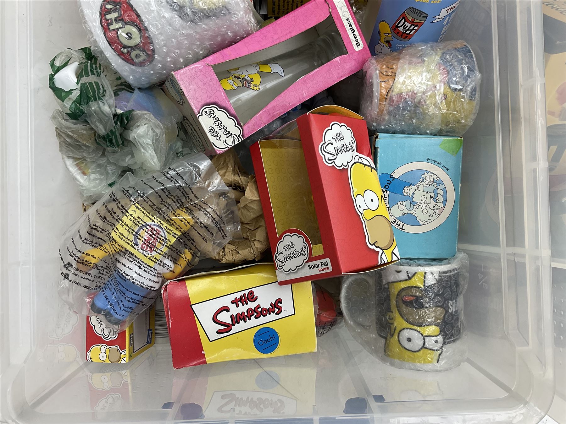 Large quantity of The Simpsons merchandise and memorabilia, to include Micro Scalextric, mugs, jigsaw, bottle openers, solar pal, glasses, etc, many boxed