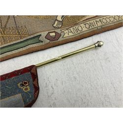 Three tapestries comprising 20th century wool tapestry panel of a medieval nobleman upon a horse with a castle in the distance, together with a smaller tapestry depicting The English Coat of Arms, both hung on rails, and further depicting village scene, largest approx 132cm x 95cm