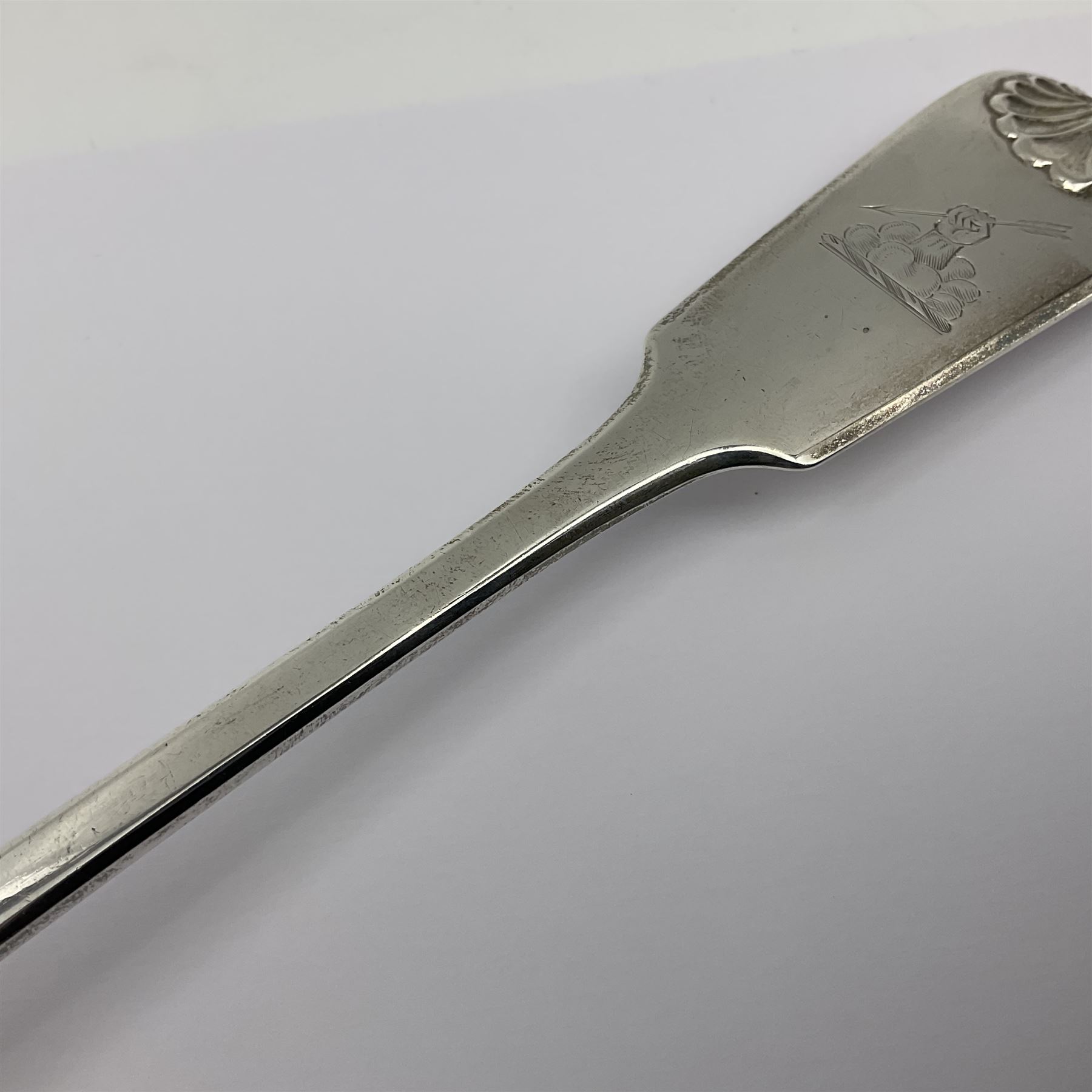 Victorian Newcastle silver Fiddle Shell pattern serving spoon, the terminal engraved with crest of a fist holding an arrow aloft, hallmarked Lister & Sons, Newcastle 1862, L31cm