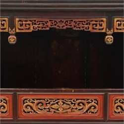 Chinese black lacquer Buddha cabinet, moulded top over open display recess framed by pierced geometric fretwork and corner spandrels, the base fitted with an arrangement of five drawers with carved and gilt scrollwork panels, on square supports with shaped apron brackets
