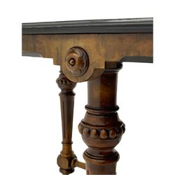 Late Victorian walnut centre table, moulded octagonal top with highly figured quarter veneers, banded in amboyna and ebony with boxwood stringing, the shaped skirt decorated with flower head roundels, on turned and fluted supports joined by fluted x-shaped stretcher rails, on brass and ceramic castors 