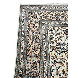 Persian Kashan ivory ground rug, decorated with curled leafy branches and palmettes, the border with scrolling design decorated with further palmettes, within floral pattern guard stripes