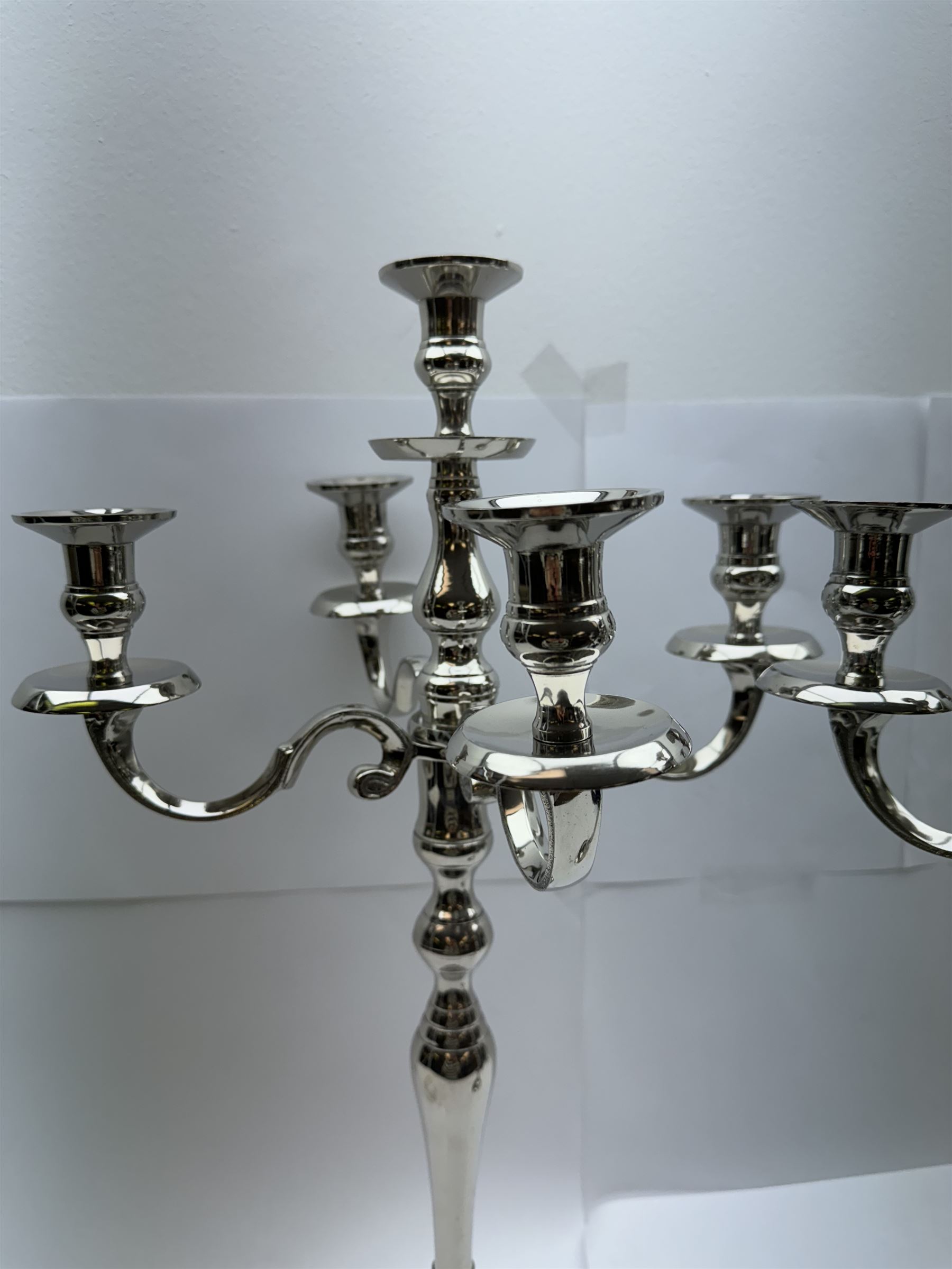 Pair of four branch candelabras, urn-shaped nozzles raised upon scroll branches supported from tapering central stem, with a stepped circular base, H59cm