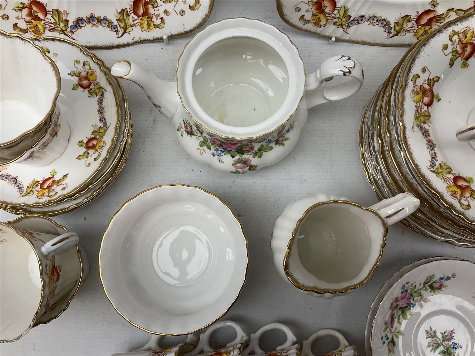 Quantity of Royal Albert tea wares to include 'Moss Rose' teapot, sucrier and saucers, together with teacups, saucers, side plates, jug etc decorated with orange, yellow and blue floral sprays with gilding upon plain ground, all stamped Royal Albert beneath