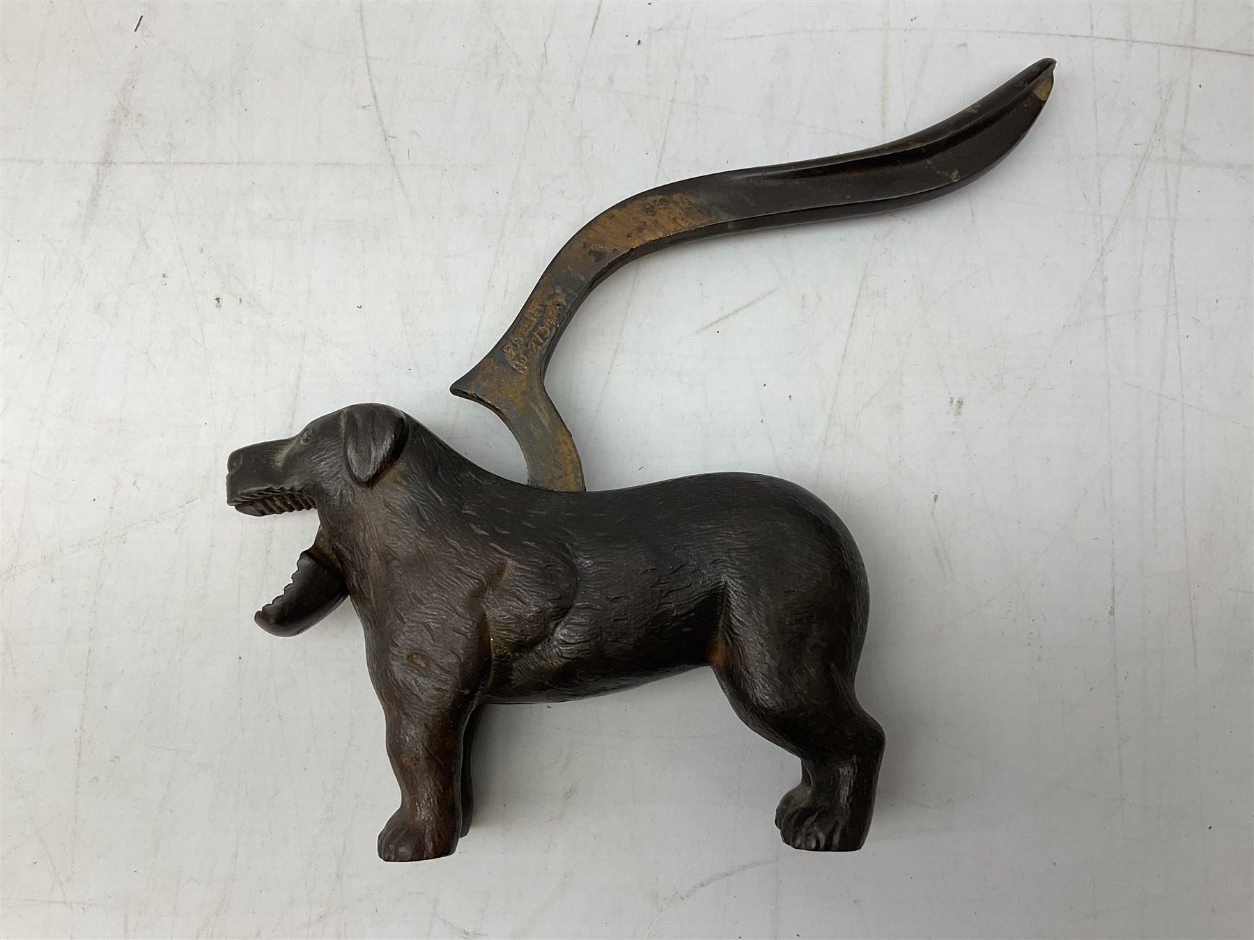 Cast metal nutcracker, in the form of a dog together with a pair of Swift Saratoga 8x40 binoculars in leather case and a hip flask, the glass flask covered in leather to the top with a detachable silver plated cup to base