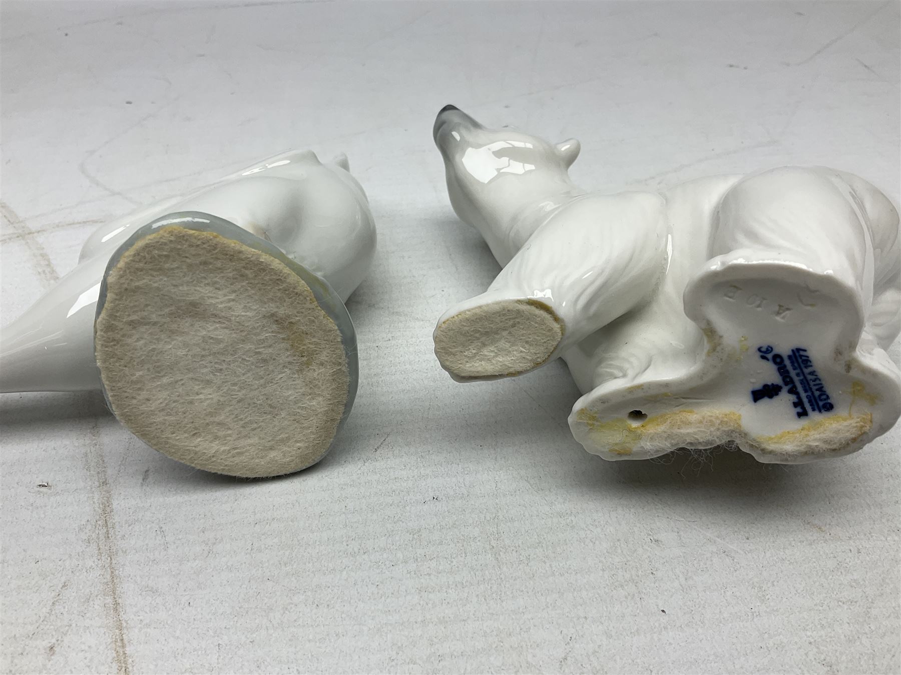 Seven Lladro figures, comprising Playful Puppy no 9135, Platero and Marcelino/Boy Hugging Donkey no 1181, Mini Seal Family no 5318, Attentive Polar Bear no 1207, Seated Polar Bear no1209, Eskimo Boy with Pet no 5238 and Girl with Geese no 1035, together with Nao goose