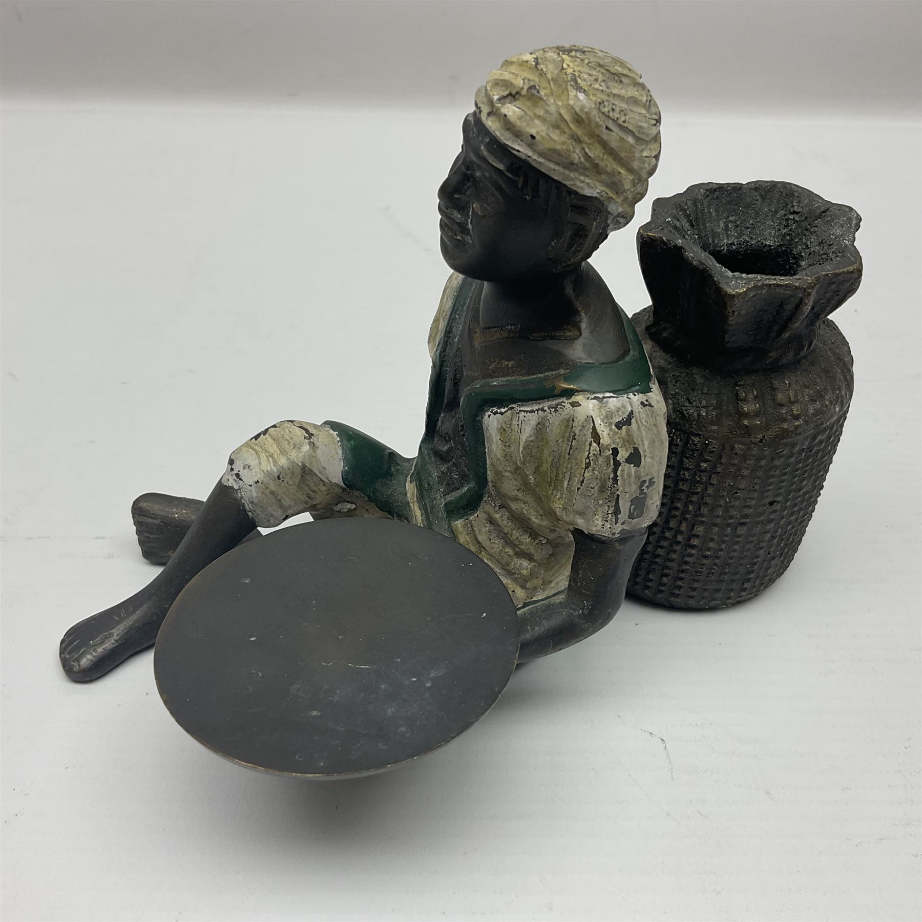 Bronze figure of a seated man resting on a sack