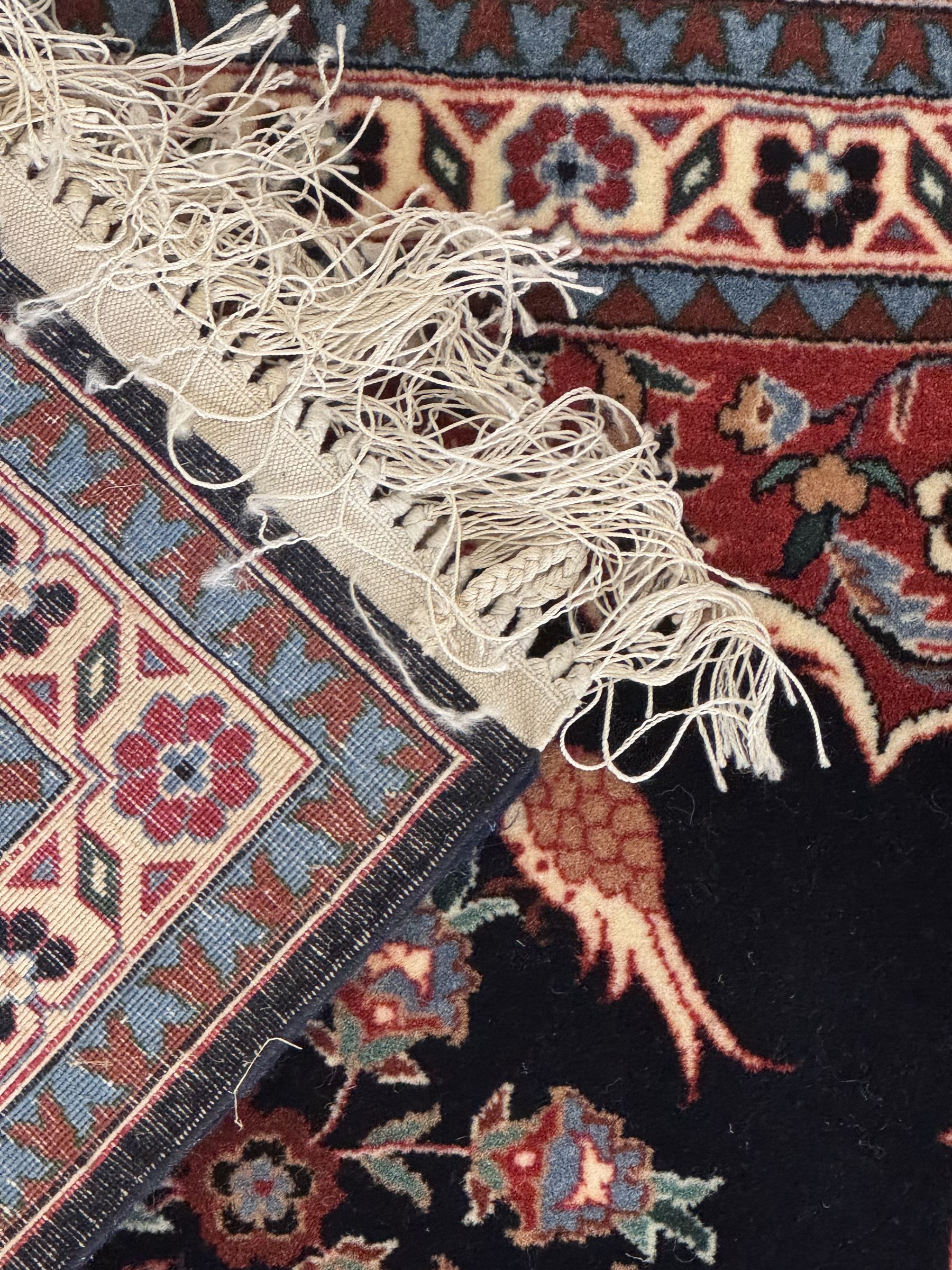 Persian-style wool rug, cream field with floral and geometric motifs, wide floral border (74cm x 142cm); Persian wool rug, beige field with dense floral patterns, narrow floral border (70cm x 144cm); Tribal wool rug, red and navy with diamond motifs (96cm x 60cm); Persian pictorial wool rug, black field with vase, birds, and floral border (70cm x 73cm)