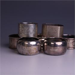 Seven silver napkin rings, of varying design and each with engraved initials, all hallmarked