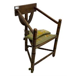 19th century swedish monk's chair, the oak frame with triangular seat and sloped arms, the backrest carved with geometric chipwork and a central pierced medallion 