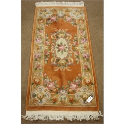  Small Chinese washed woollen rust ground rug with traditional floral pattern, 155cm x 78cm  
