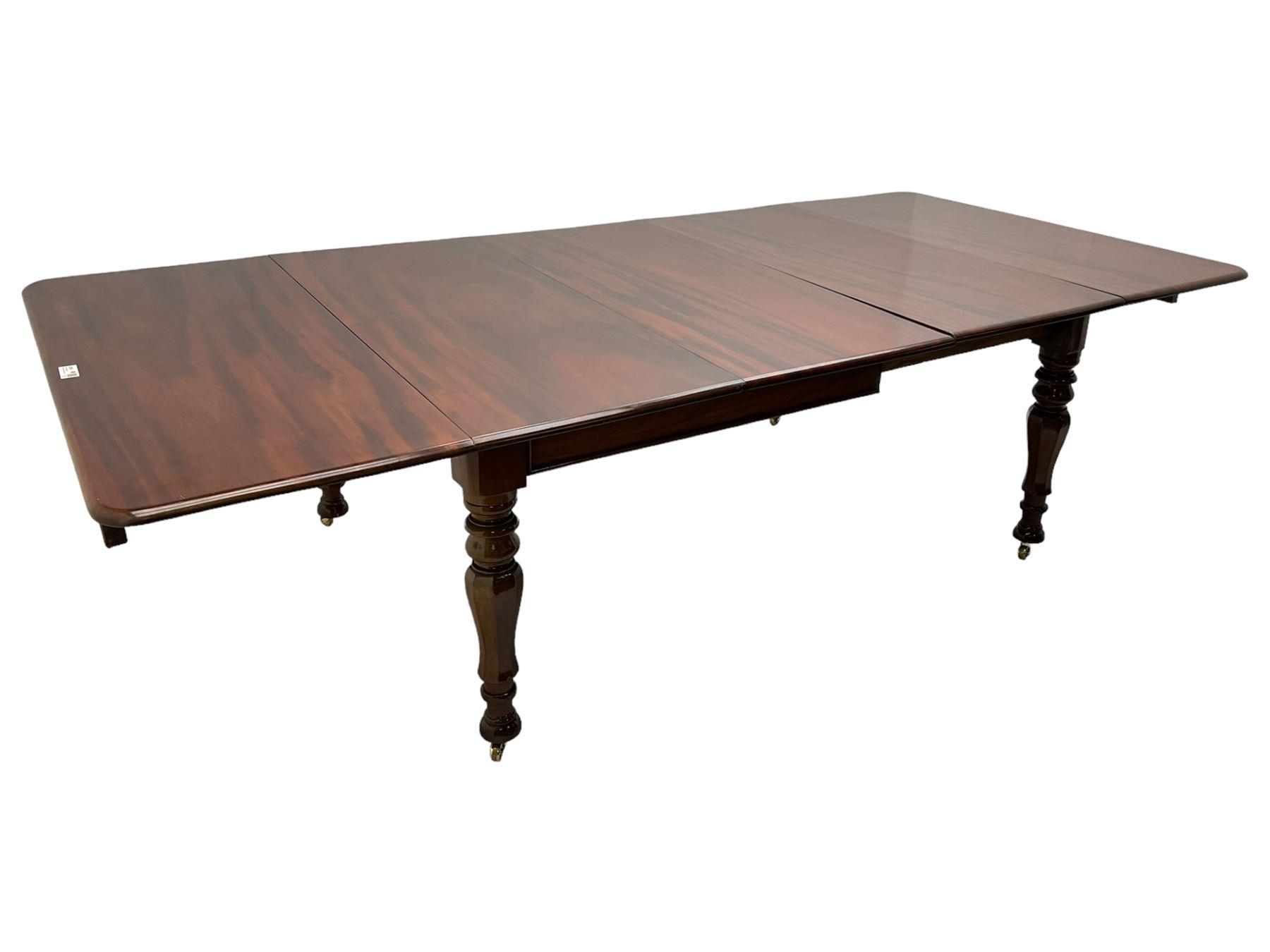 19th century mahogany extending dining table with three additional leaves, rectangular top with rounded corners, pull-out action, on turned and faceted supports with brass castors