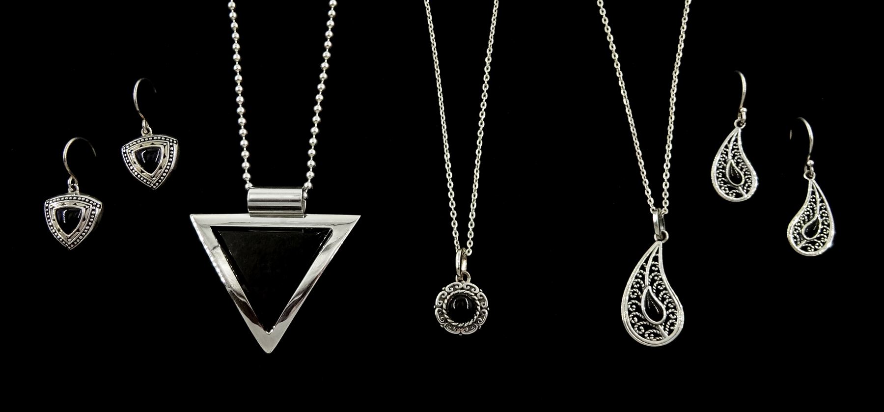 Silver contemporary triangular Whitby jet pendant necklace, two other silver Whitby jet necklaces; one round and one in a paisley shape, and two pairs of Whitby jet earrings; matching paisley shape and the other pair cushion triangle shaped, all stamped 925