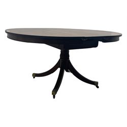 Regency design mahogany extending dining table, circular top with reeded edge and pull-out mechanism to accommodate additional leaf, raised on a carved central baluster column with acanthus detailing, supported by a quadruple reeded splay base terminating in brass caps and castors

