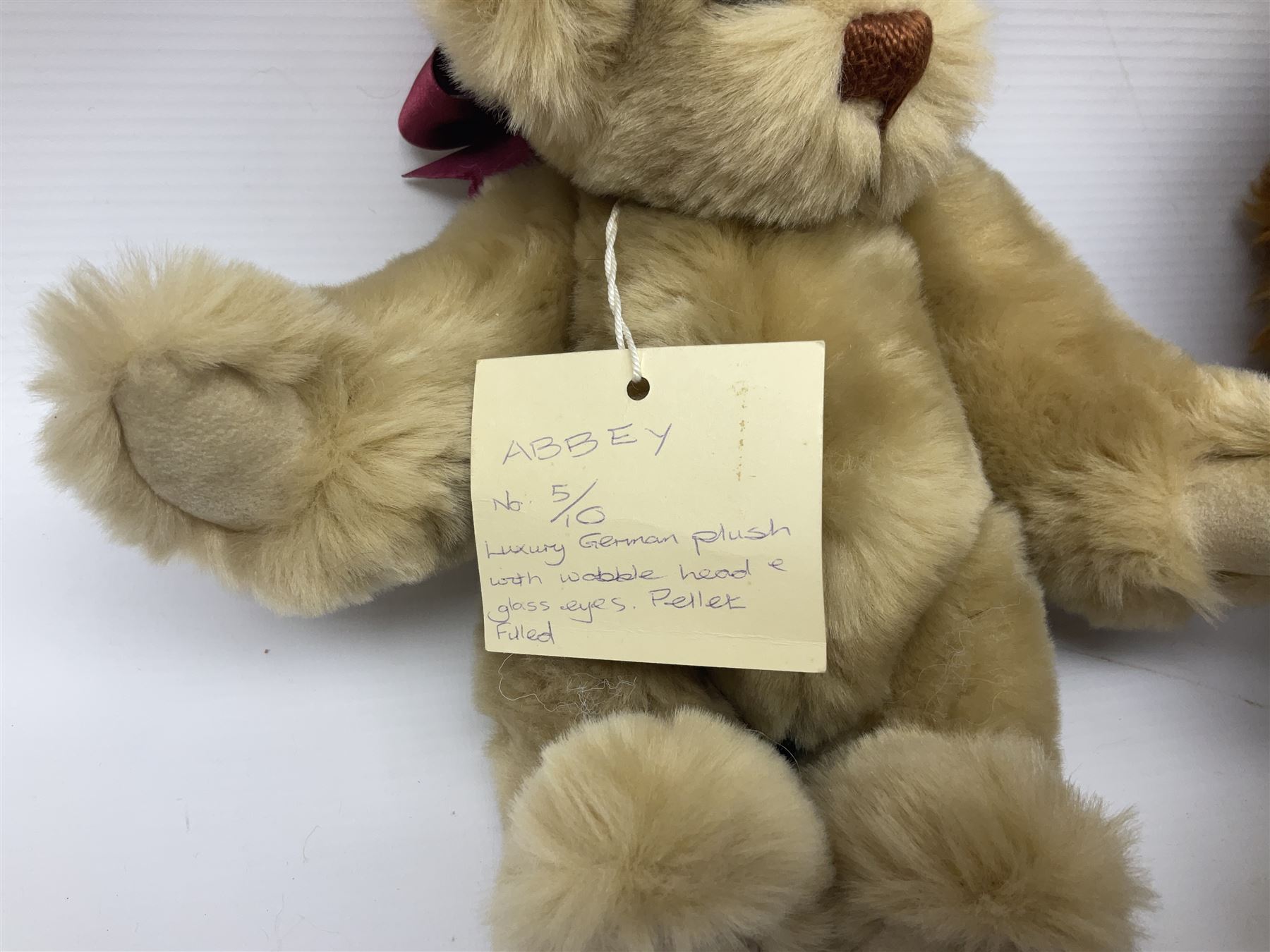 Group of five teddy bears comprising ‘George’ a unique pellet filled bear with glass eyes and velvet paws H38cm, and ‘Abbey’ a luxury German plush with wobble head and glass eyes no.5/10 H24cm, both with Teddies from Bearyland labels; along with two light blonde mohair H. M. Bears and Boyds Bears ‘T. F. Wuzzies’ no. 595140 (5)