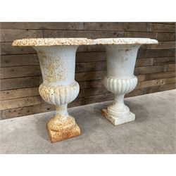 Pair of large Victorian design white painted cast iron campana shaped garden urns, egg and dart rim over a gadrooned underlobe, tapering column on square plinth base