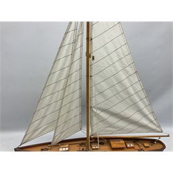 Wooden built model yacht with linen sails and mounted on wooden base, H86cm