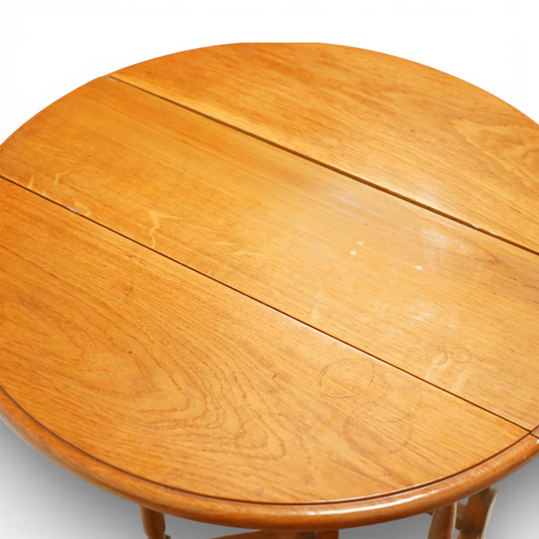 Late 20th century small oak gate leg side table, with circular drop-leaf top formed of three planks, raised on turned supports with gate legs and rectangular stretchers