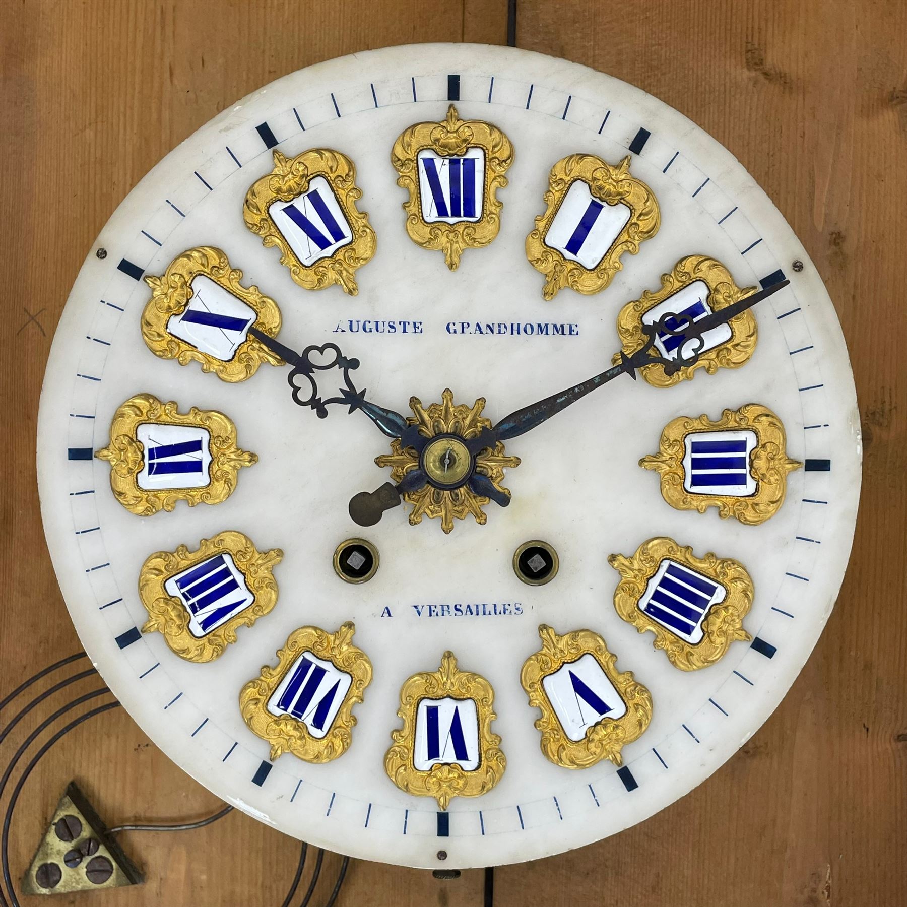 Auguste GP. Andhomme - French vineyard clock,  late 19th century 8-day twin train spring driven wall clock with enamelled and inlaid brass decoration within an ebonised and glazed case, circular enamel dial with cartouche Roman numerals, minute markers, pieced steel hands and a chased brass slip, striking movement, sounding the hours and half hours on a coiled gong. With pendulum and key.  
