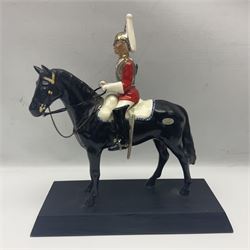 Mounted Lifeguard upon a black horse, in the style of Beswick, upon a wooden plinth, H31cm