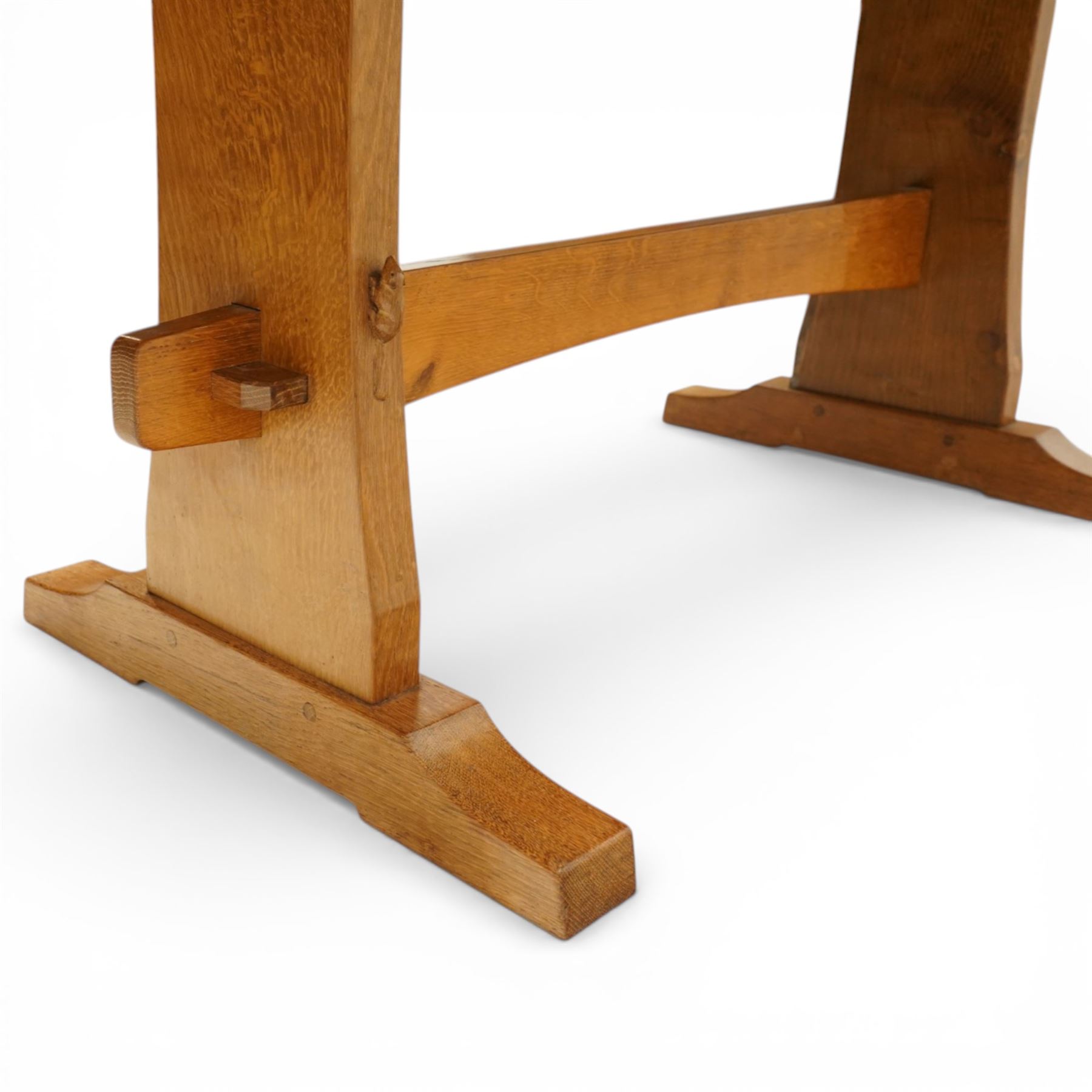 Beaverman - oak adzed top refectory table, the rectangular top raised on twin trestle supports with shaped feet united by a stretcher, the joints secured with exposed pegs, with carved beaver signature, by Colin Almack of Sutton near Thirsk