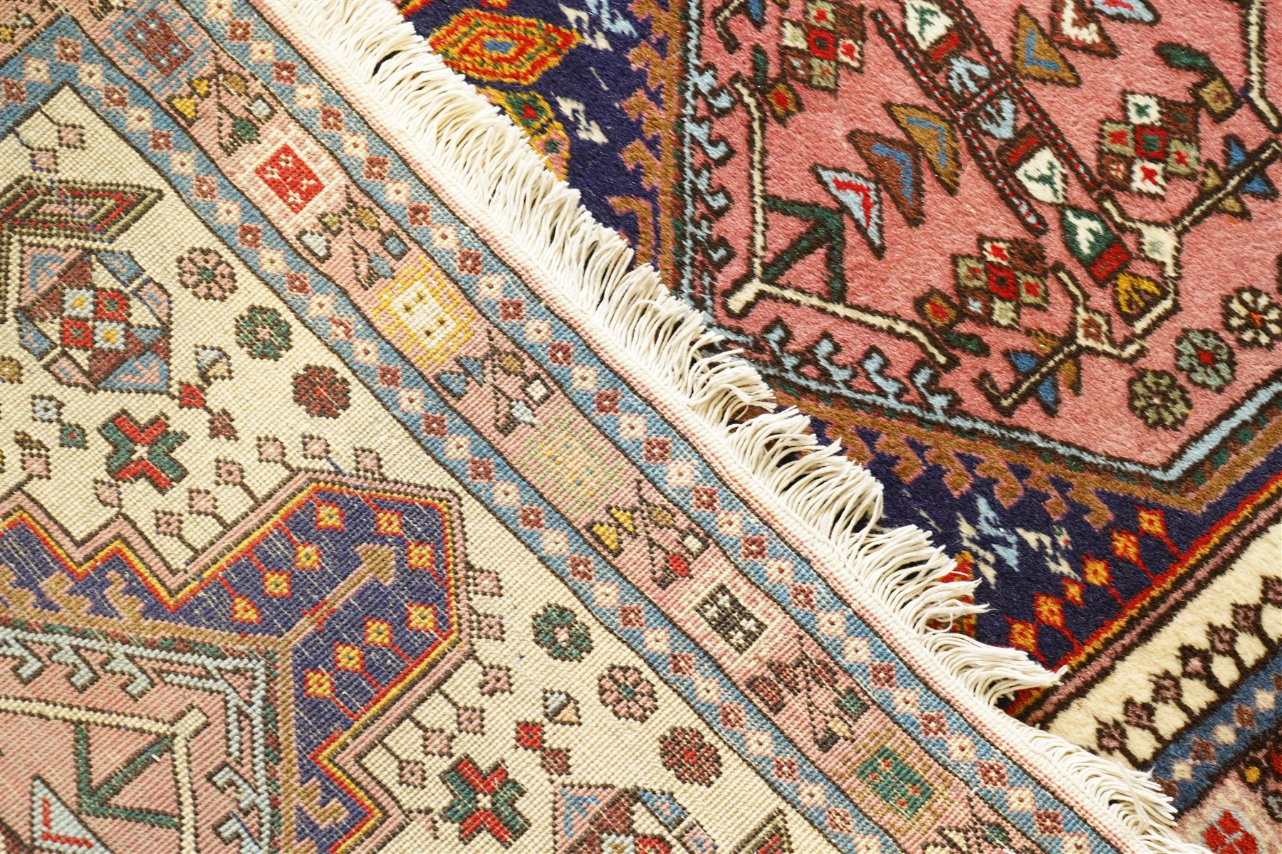 Persian Iranian wool runner, with a series of stepped hexagonal medallions in rust, olive and ivory against and deep navy field, the medallions are filed with floral and latch-hook motifs, framed by and ivory guard border with geometric rosettes, flanked by a rust outer band