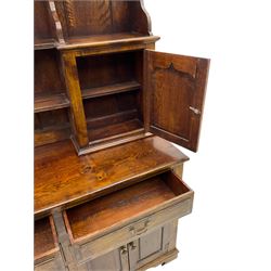 Traditional oak dresser, the moulded cornice over shaped apron, three heights plate rack fitted with two cupboards, the base fitted with six drawers and two double cupboards, panelled pointed ogee arched doors, on bracket feet