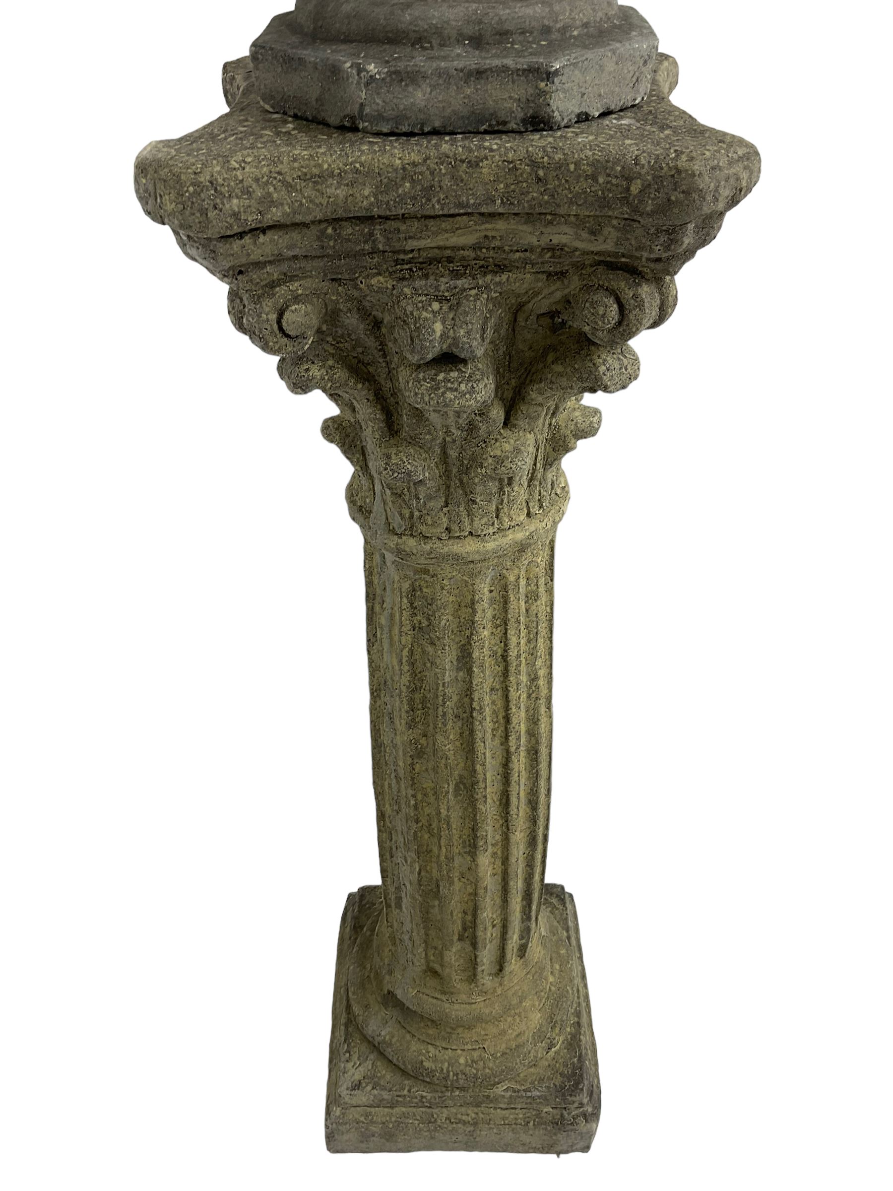 Classical design cast stone female bust depicting Artemis, raised on fluted Corinthian column with acanthus leaf capital, stepped square base, looking right 