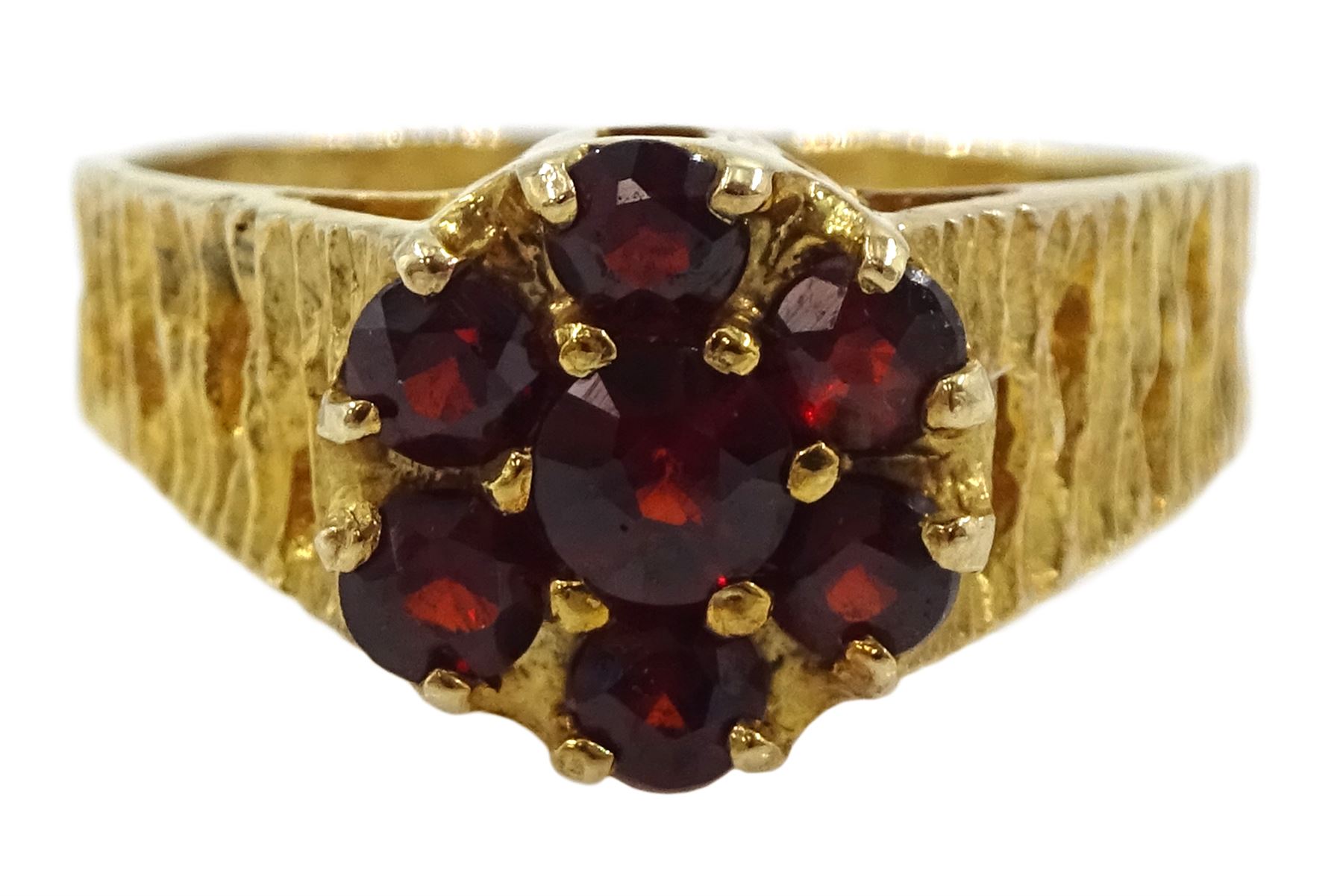 9ct gold garnet flower head cluster ring, with textured and pierced shoulders by Slade & Kempton, London 1978