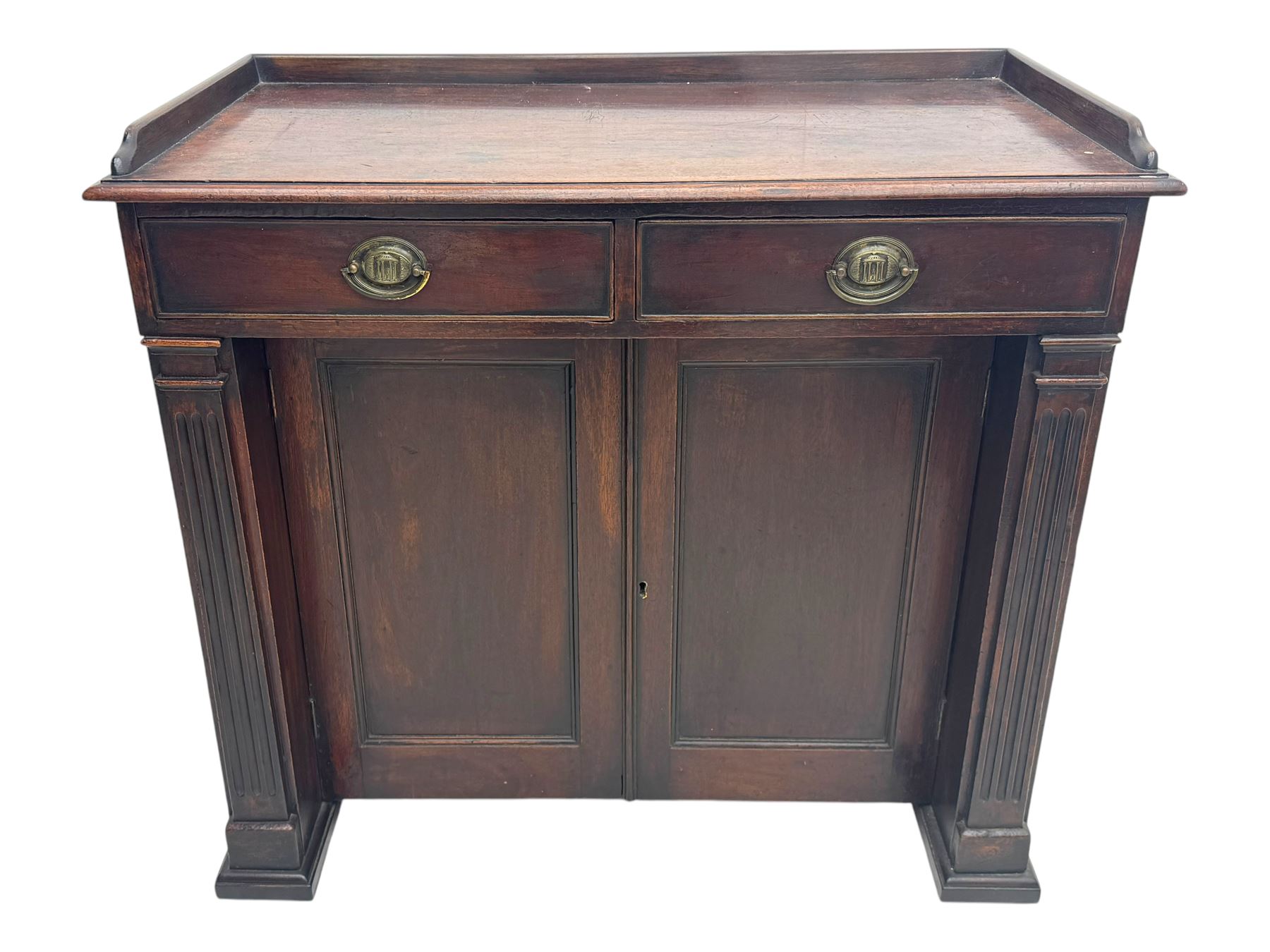 George III mahogany chiffonier or side cabinet, rectangular top with raised gallery and two frieze drawers, over double cupboard enclosing shelves, fluted side supports, raised on castors