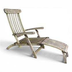 Pair of teak reclining garden steamer armchairs, each with an adjustable slatted back, curved slatted seat and footstool
