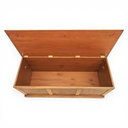 Traditional design figured elm blanket chest, with padded striped upholstered seat, over a hinged top with panelled sections below raised on a plinth base