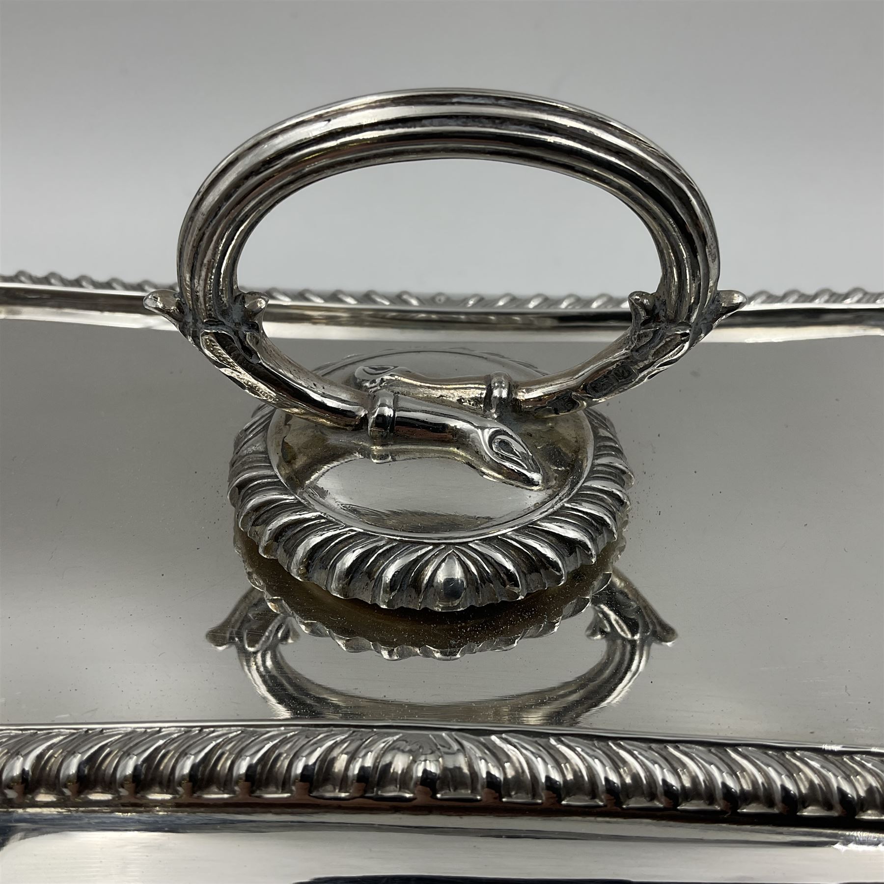 Early 20th century silver entree dish and cover, of rectangular form with shaped corners and oblique gadrooned borders to base and cover, the cover with loop 'bamboo' handle, hallmarked Thomas Bradbury & Sons Ltd, Sheffield 1930, including handle H10.5cm L24.5cm