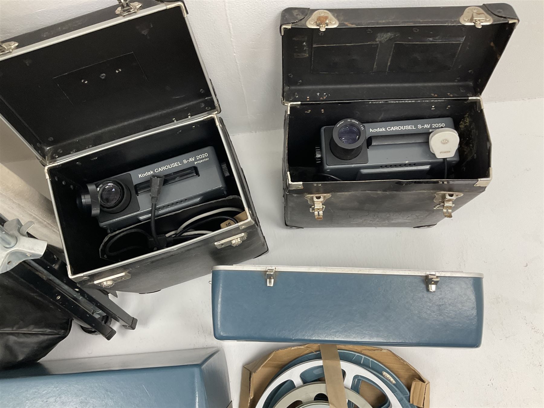 Kodak Carousel S-AV 2020 and 2050 35mm slide projectors, Kodak S-AV cassette recorder 200, Kodak S-AV programmable dissolve control, two Kodak slide carousels and a metal stand; a Singer Graflex 16 cine projector, two 16mm Charlie Chaplin film reels with sound 'Between Showers' and 'Oh What a Night', and five film spools; freestanding roll-up projection screen, and a wood framed reflective daylight projection screen