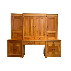 Large contemporary cherry wood break-front wall unit, the banded cornice over double cupboard with bifold doors and two drawers, flanked by four single cupboards, the base fitted with four drawers over four cupboards (W263cm, H216cm, D68cm); and a cherry wood cabinet, fitted with double cupboard over two short and two long drawers, with faux drawer facias (W81cm, H138cm, D66cm)