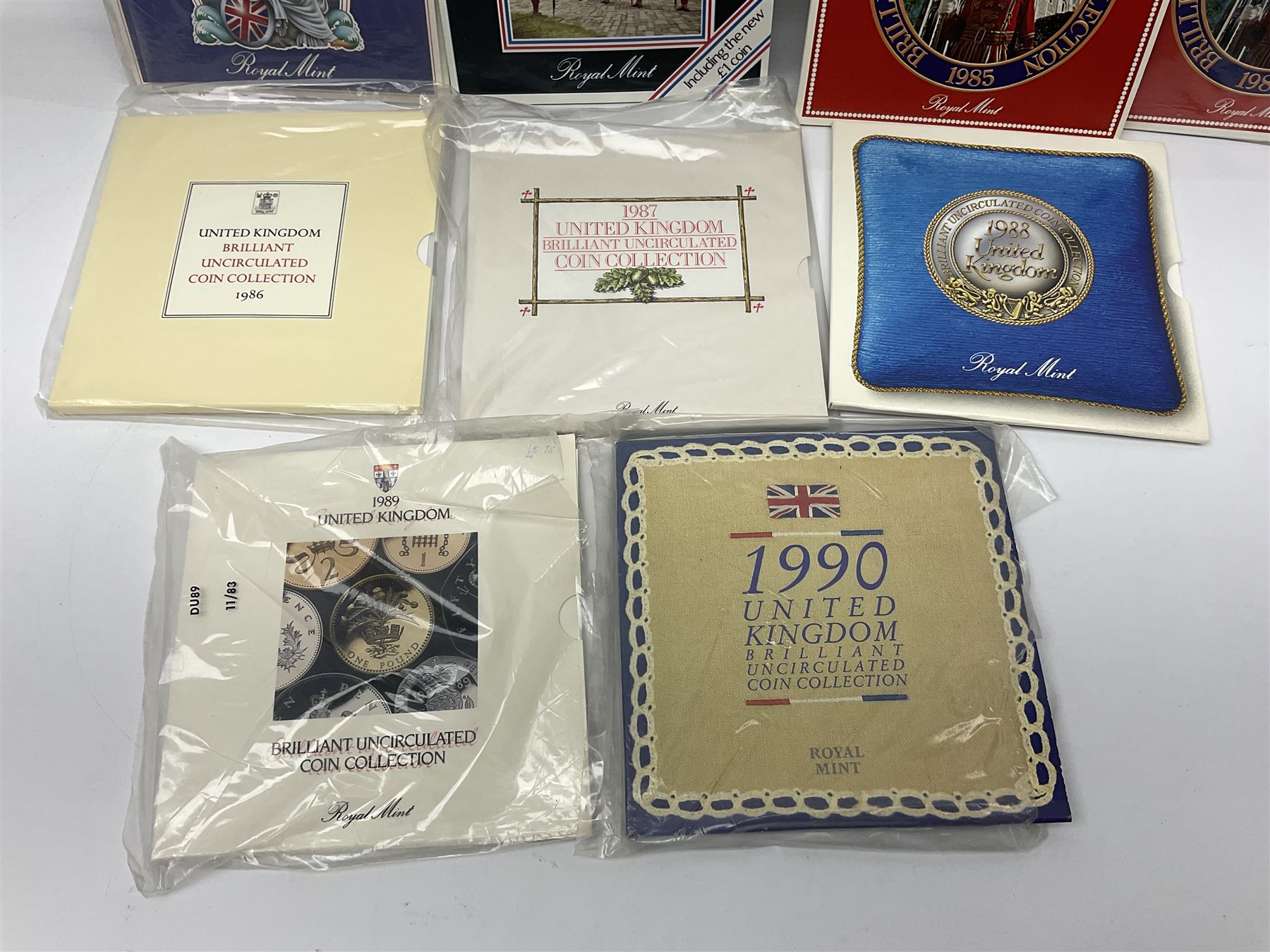 Fourteen Queen Elizabeth II United Kingdom uncirculated coin collections, dated 1983, 1984, two 1985, 1986, 1987, 1988, 1989, 1990, 1991, 1992 including dual dated 1992/1993 EEC fifty pence, 1994 and two 1995, all in card folders