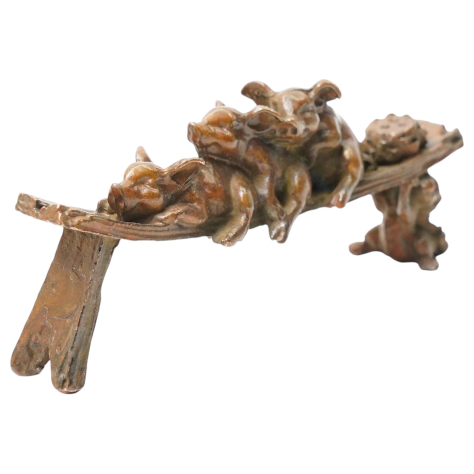 Bronze figure of three pigs resting on a bench, W10cm 
