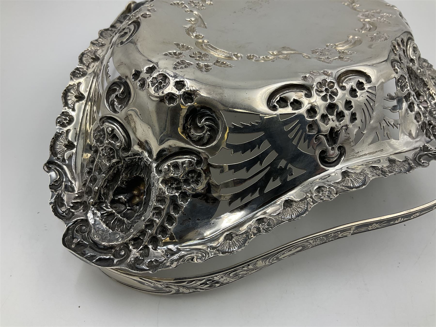 Edwardian silver swing handled basket, of navette form, with four repousse lion masks to each corner and with pierced and embossed floral, scroll and shell decoration to sides, base and handle, hallmarked Charles Horner, Birmingham 1906, height including handle H20cm