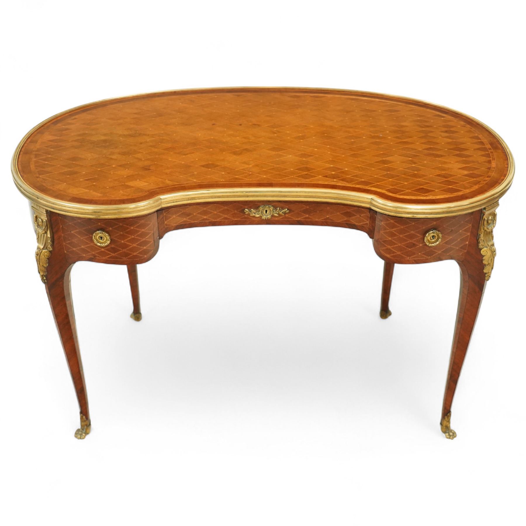 Late 19th-century Louis XV-style marquetry and gilt bronze-mounted kidney-shaped writing table, of serpentine form, top finely veneered with a trellis parquetry pattern, within a gilt bronze moulded edge, above a shaped frieze fitted with a central drawer flanked by two short drawers, similarly inlaid side and legs, knees with gilt bronze foliate mounts and cabriole legs terminating in gilt bronze sabots