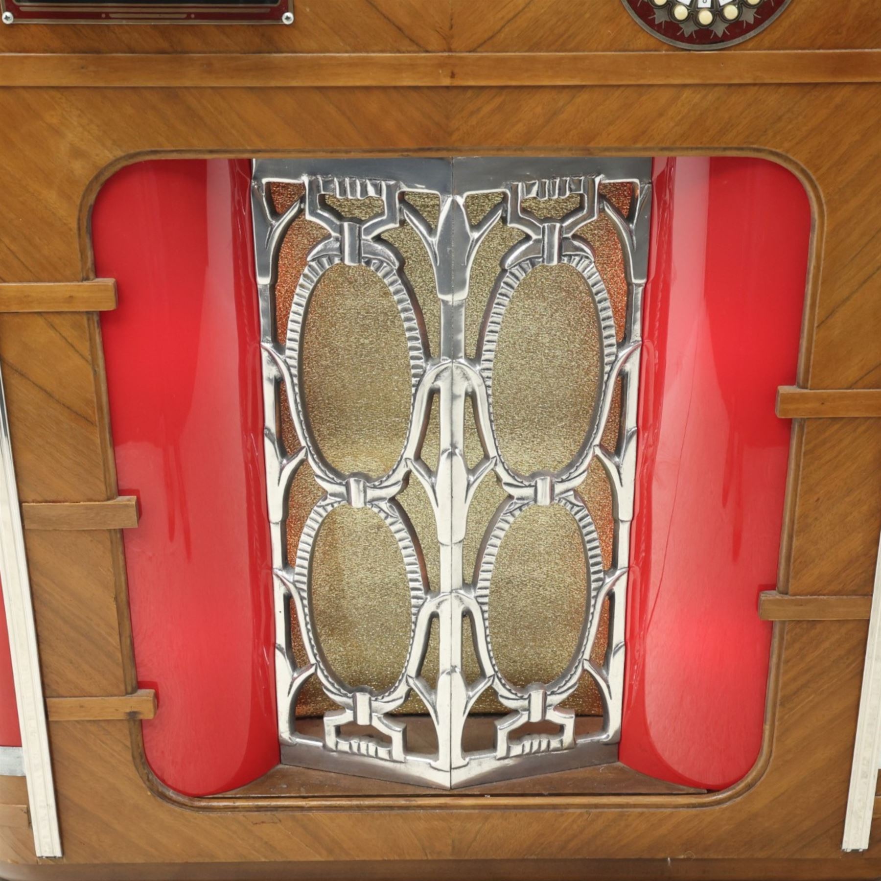 Rudolf Wurlitzer Company - Model 616 'Simplex' 1937 jukebox, figured walnut veneered cabinet with illuminated red and amber side panels enclosed by chromed uprights, glazed upper record compartment, cast Art Deco speaker grille, coin-operated push-button selection panel with circular title index, raised on a moulded base