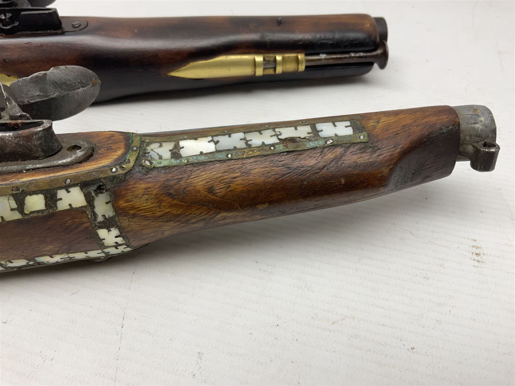 Modern non-firing reproduction Tower flintlock pistol marked with crowned GR and Tower to the lock, brass skull crusher butt and fittings L40cm overall; another Indian/Moorish reproduction flintlock pistol with mother-of-pearl inlay; and a modern die-cast replica Colt style revolver (3)