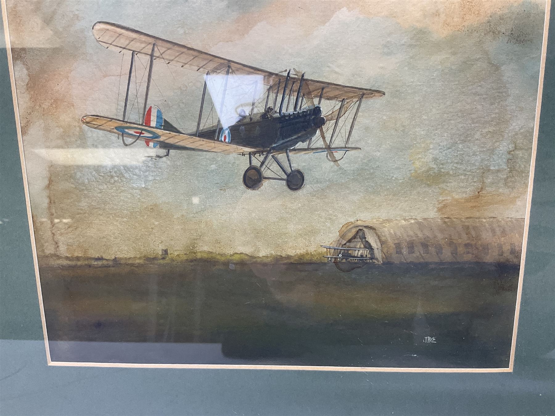T. Page (early 20th century) - RFC bi-plane in flight over an airfield, bears labels verso 'BE2.B. Dennes Lane R.F.C. Lydd Flying School Oct.1916' and 'Lt. Gerrard R.F.C Lydd 1917 Evening Anti Zeppelin Training Flt. B. Dennes Lane Circum & Bumps', signed watercolour 20.5 x 22.5cm, later mahogany stained frame