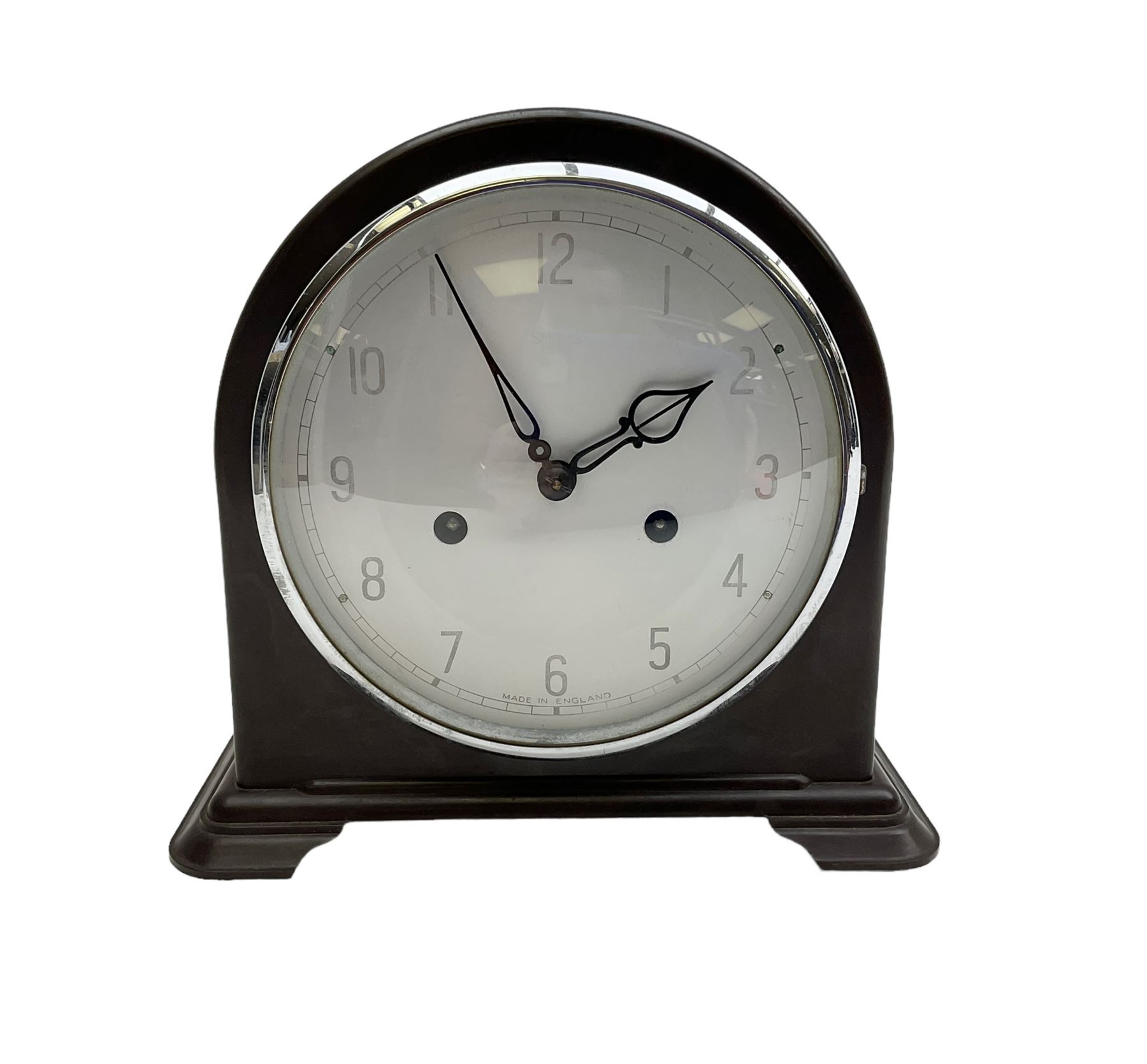 Enfield- English 1950's 8-day mantle clock in a round topped brown Bakelite case on splayed feet, with a glazed chrome bezel and silvered dial with Arabic numerals and original pierced hands, twin train spring driven movement, sounding the hours and half-hours on a coiled gong. With pendulum & key.  