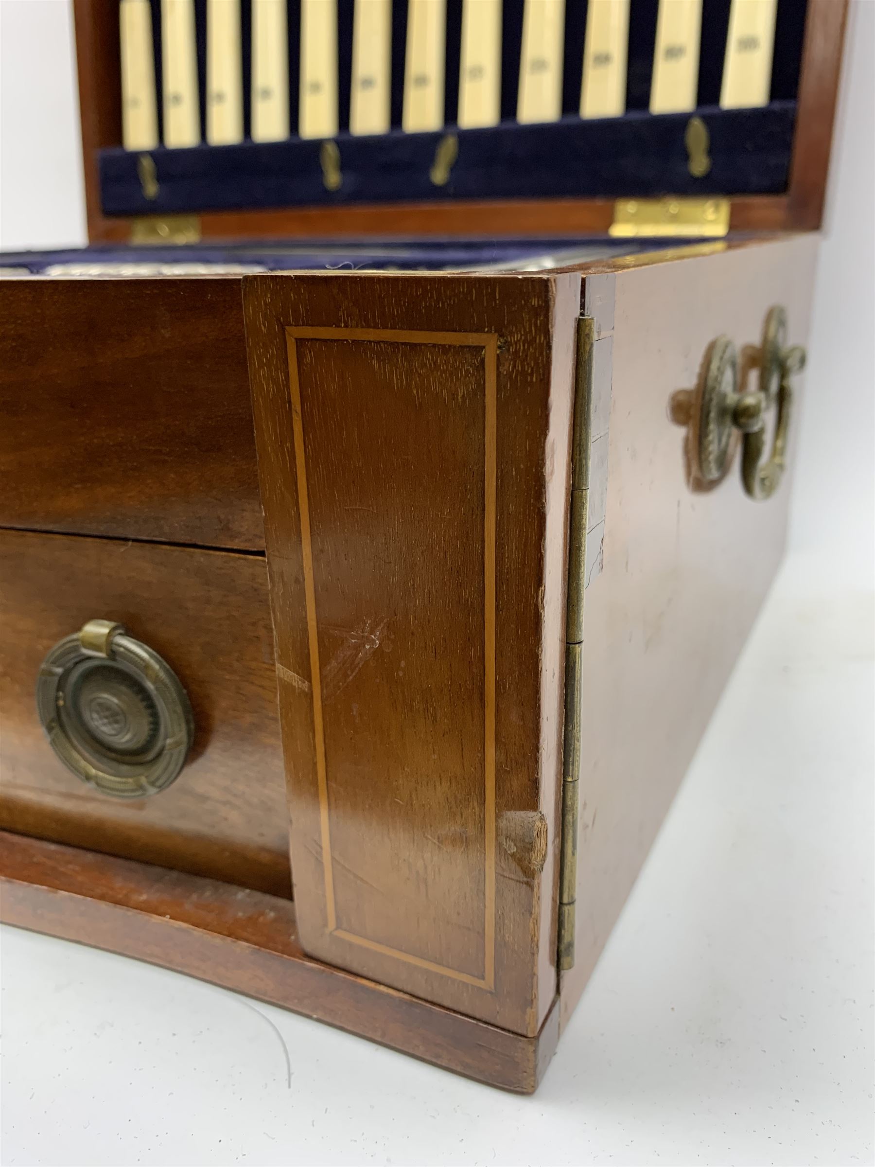 Late 19th/early 20th century composite canteen of silver flatware, contained within an early 20th century mahogany serpentine fronted case with twin drop carry handles, and hinged cover with boxwood stringing and central inlaid shell motif, above a single drawer with twin ring handles and Wellington style locking system, the cover and drawer opening to reveal plaque for Spink & Sons Ltd London, and fitted interior containing ivory handled knives, ivory handled carving set, and silver Hanoverian and Old English pattern cutlery, each with engraved monogram to terminal, hallmarked London, makers Spink & Son (John Marshall Spink), Goldsmiths & Silversmiths Co, and Chawner & Co (George William Adams), various dates ranging 1880-1923, gross weighable silver 92.59 ozt (2880 grams)