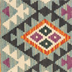 Chobi flatweave kilim runner with a repeating stepped diamond medallion design in live green, rust, teal, purple, and ivory, framed by chevron and geometric borders