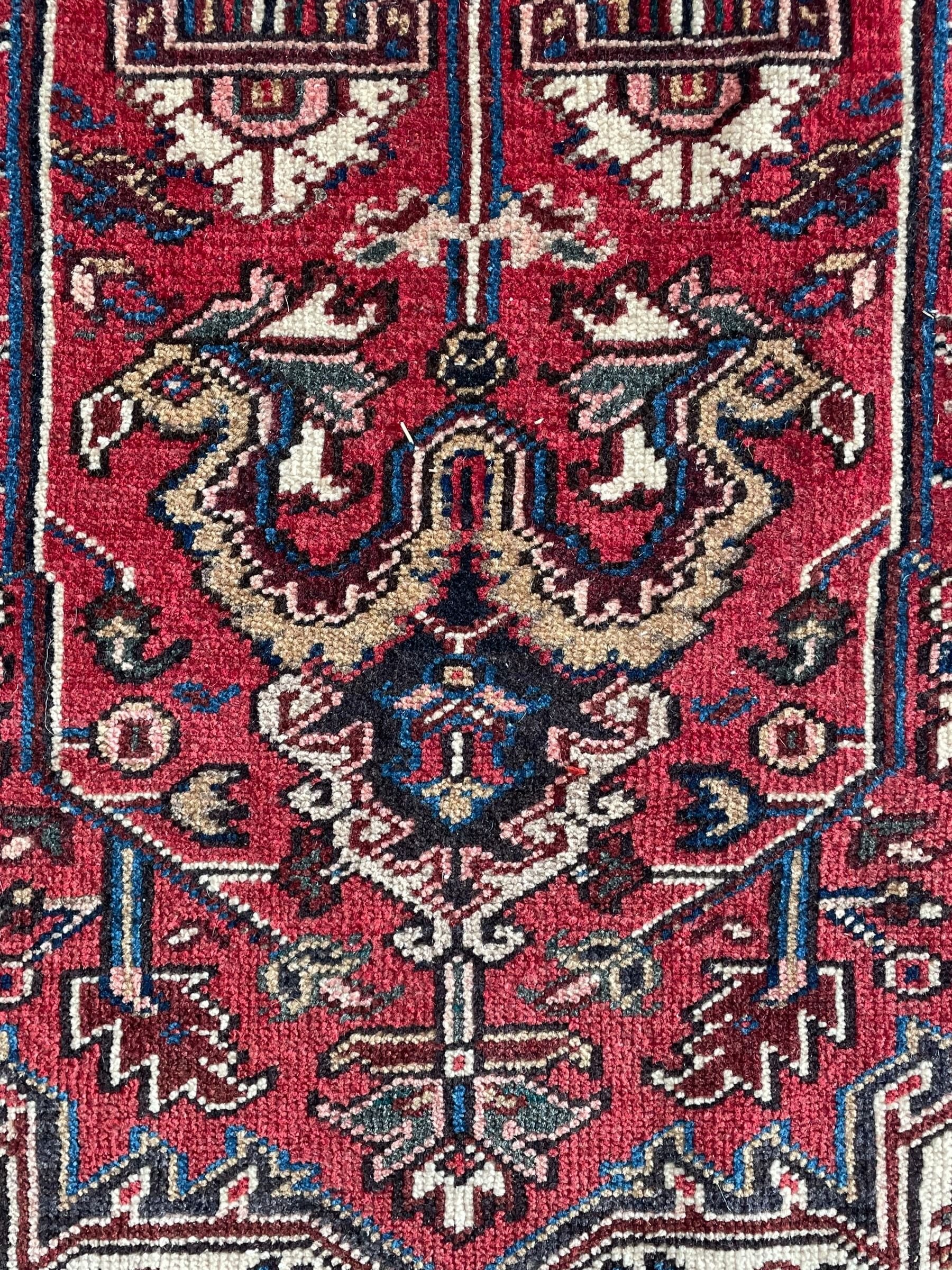 Persian Heriz red ground rug, large medallion decorated with palmettes and Ejder motifs, the border decorated with stylised plant motifs, within floral design guard stripes 