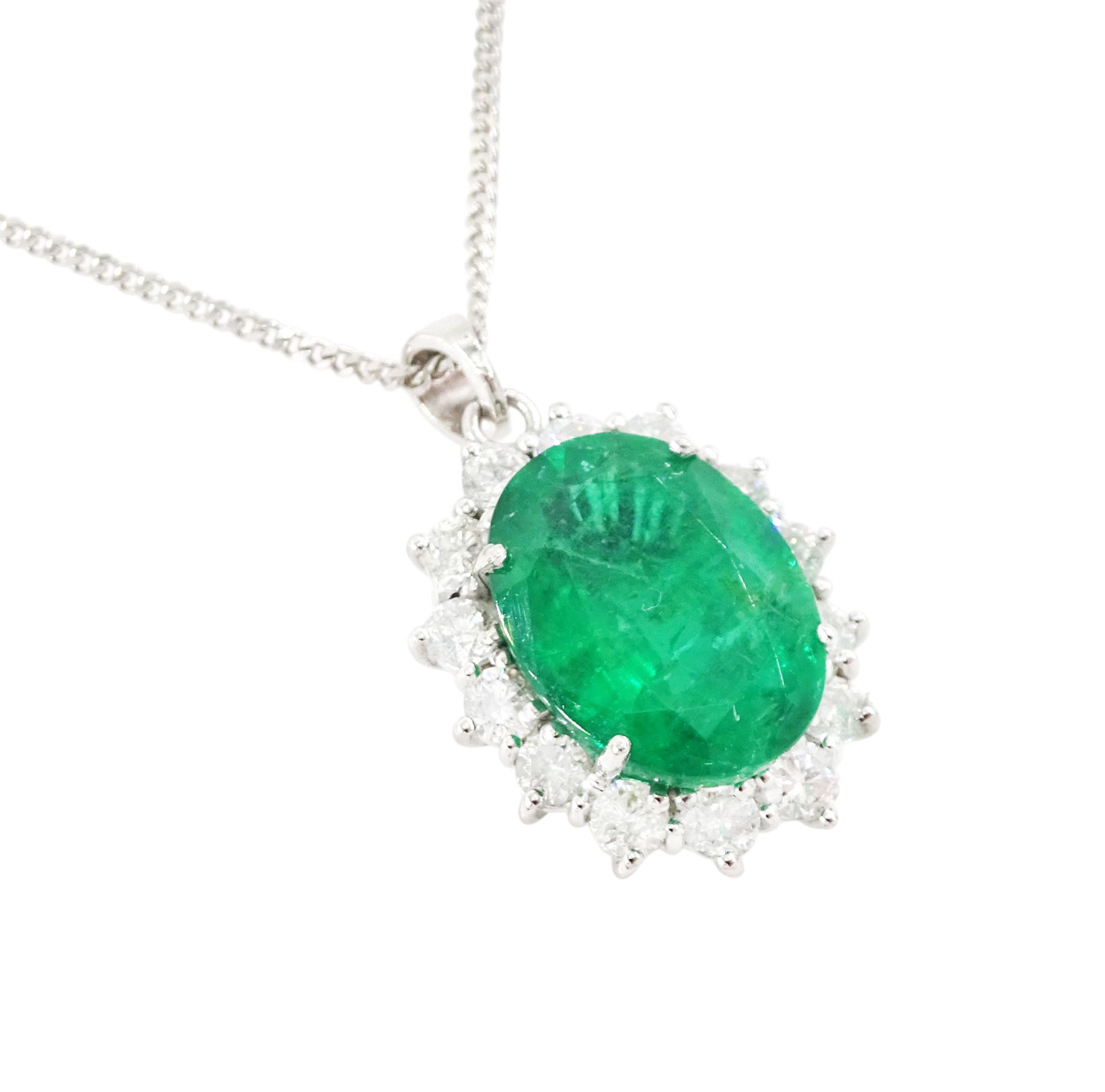 18ct white gold emerald and diamond pendant necklace, single oval cut  emerald of approx 3.25 carat, surrounded by fourteen round brilliant cut diamonds, on a fine link chain necklace, hallmarked, total diamond weight approx 0.50 carat